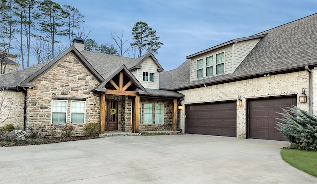 view of front facade with a shingled roof, a chimney, and concrete driveway