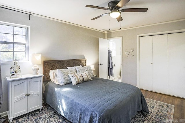 bedroom featuring ceiling fan, a closet, wood finished floors, and crown molding