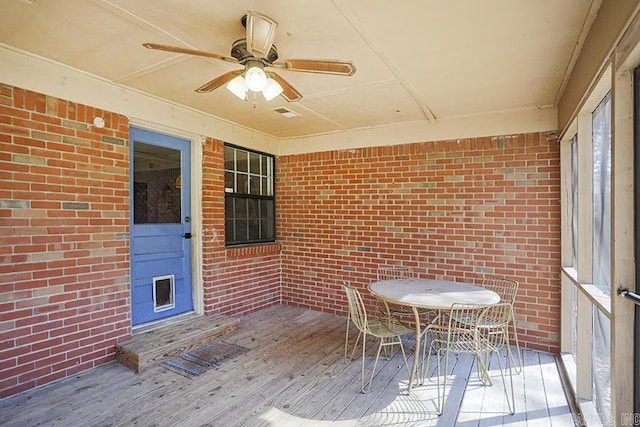 unfurnished sunroom featuring ceiling fan