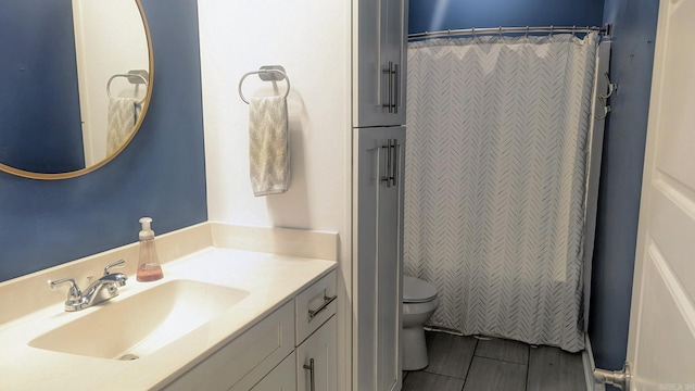 full bathroom featuring a shower with shower curtain, vanity, and toilet