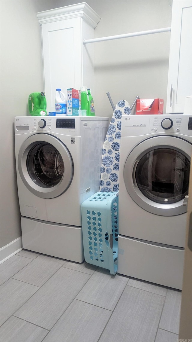 laundry area featuring washer and clothes dryer and cabinet space