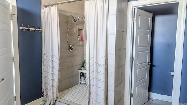 bathroom featuring a shower stall and baseboards