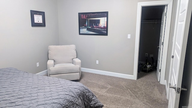 bedroom featuring a walk in closet, a closet, carpet flooring, and baseboards