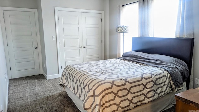 carpeted bedroom featuring baseboards and a closet