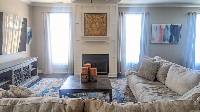 living area featuring crown molding, a fireplace, and a wealth of natural light