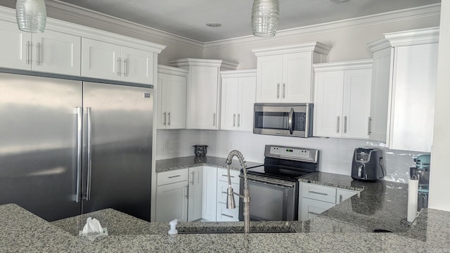 kitchen featuring stainless steel appliances, dark stone countertops, and white cabinetry