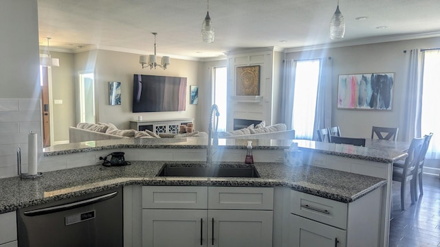 kitchen with dishwasher, ornamental molding, open floor plan, hanging light fixtures, and a sink