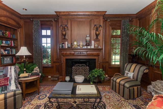 living room with ornamental molding, a fireplace, wood finished floors, and built in features