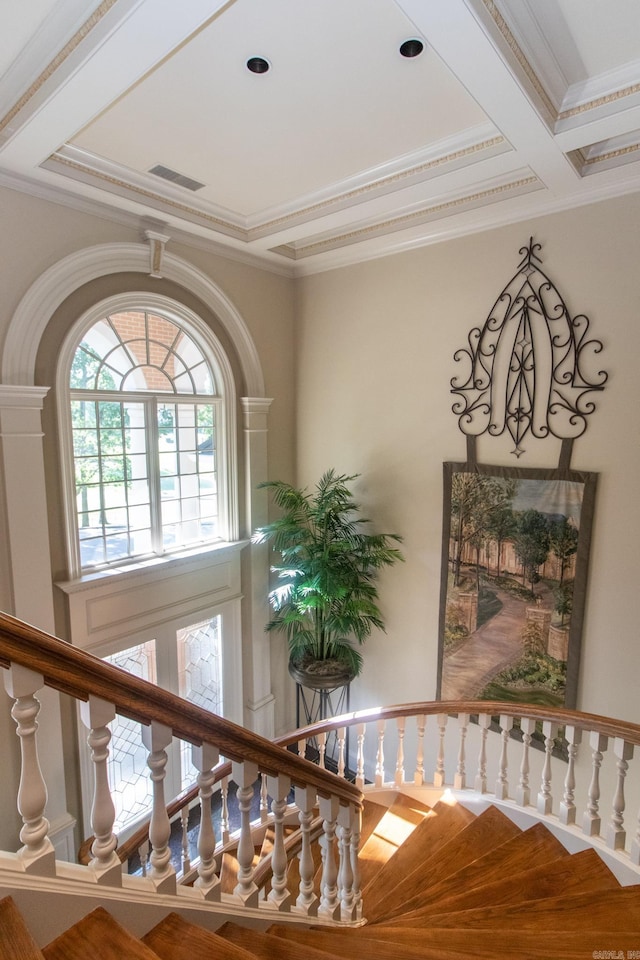 staircase featuring ornamental molding, coffered ceiling, wood finished floors, and visible vents