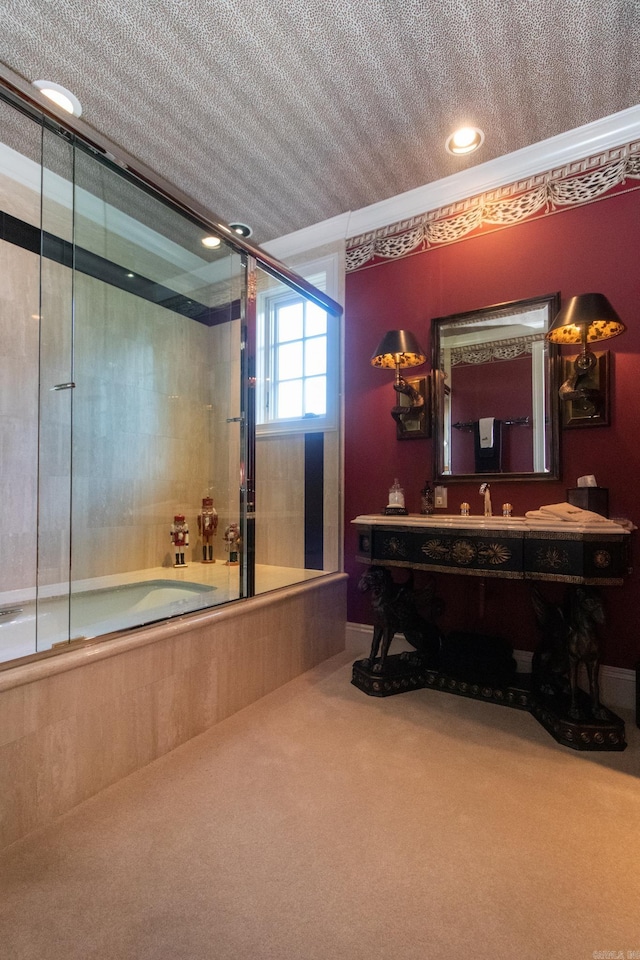 bathroom with a textured ceiling, combined bath / shower with glass door, and vanity