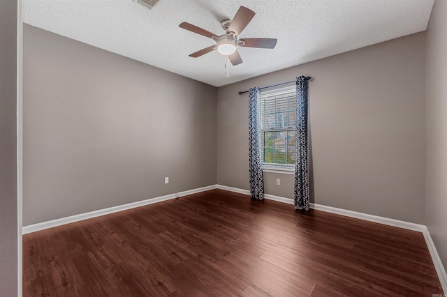 empty room with ceiling fan, a textured ceiling, baseboards, and wood finished floors