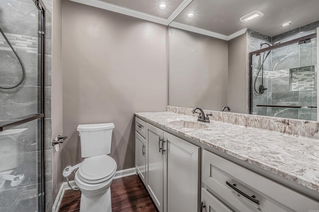 full bath featuring crown molding, toilet, a shower stall, vanity, and wood finished floors