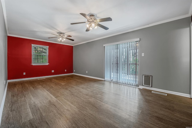 spare room with ornamental molding, visible vents, baseboards, and wood finished floors