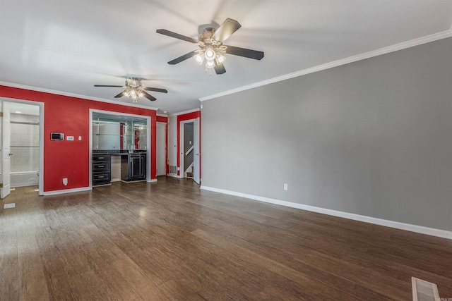 unfurnished living room with visible vents, crown molding, baseboards, and wood finished floors