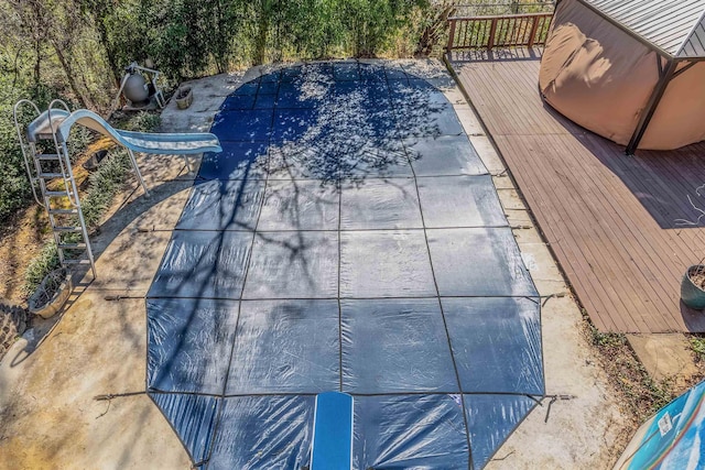 view of pool with a water slide and a wooden deck