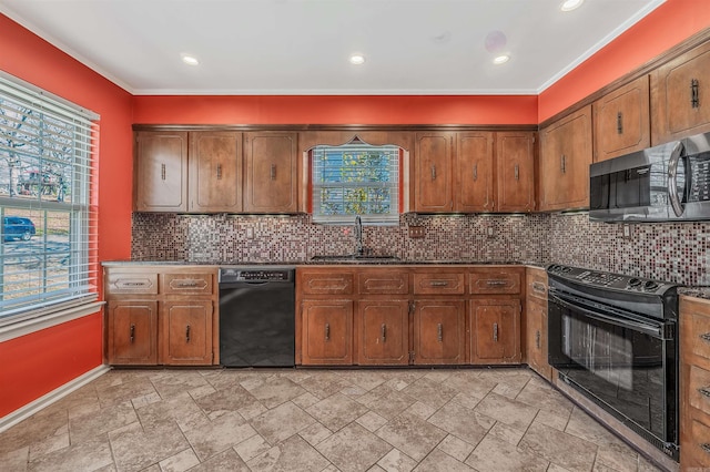 kitchen with tasteful backsplash, a healthy amount of sunlight, a sink, and black appliances