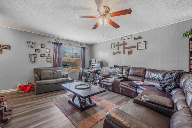 living area with a textured ceiling, a ceiling fan, and wood finished floors