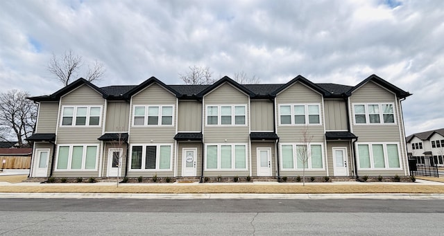 townhome / multi-family property featuring board and batten siding, entry steps, and fence