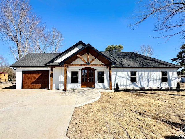 modern farmhouse with a garage, concrete driveway, french doors, roof with shingles, and board and batten siding