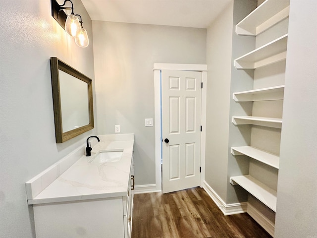 bathroom featuring baseboards, wood finished floors, and vanity