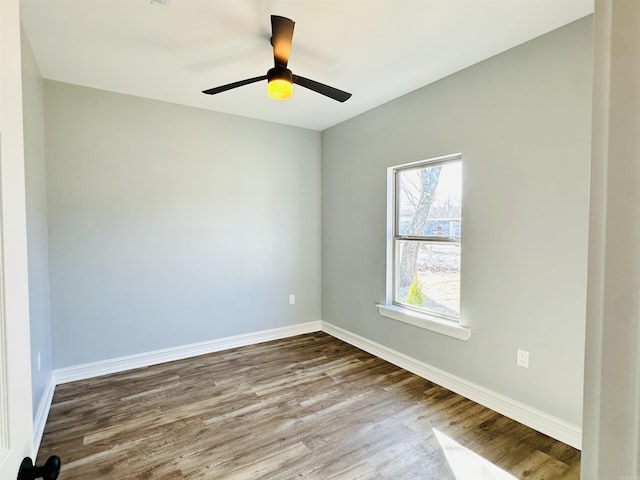 spare room featuring a ceiling fan, baseboards, and wood finished floors