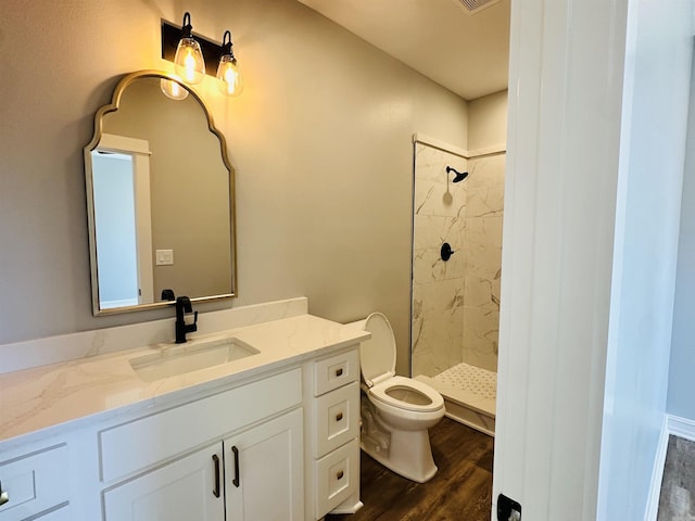 full bath featuring toilet, a stall shower, wood finished floors, and vanity