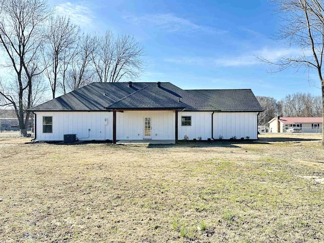 rear view of property with a lawn and cooling unit