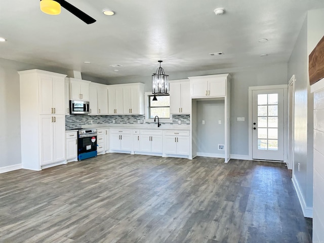 kitchen featuring wood finished floors, appliances with stainless steel finishes, decorative backsplash, and a healthy amount of sunlight