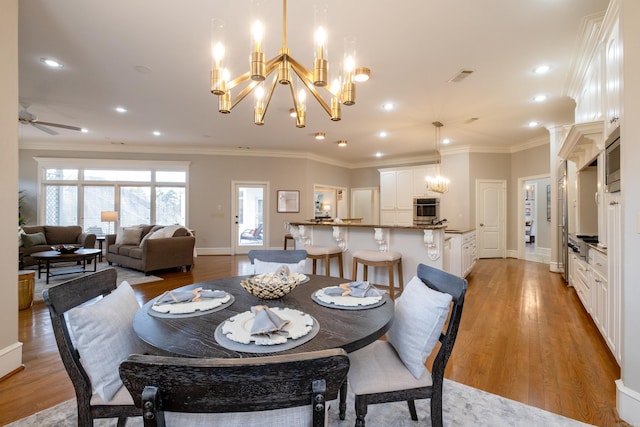 dining space featuring visible vents, baseboards, light wood-style flooring, ornamental molding, and recessed lighting