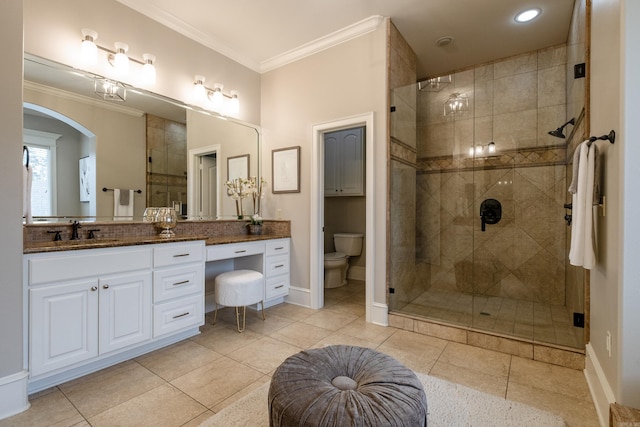 bathroom featuring toilet, a shower stall, baseboards, and crown molding