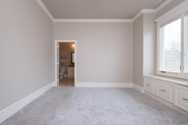 empty room featuring baseboards, ornamental molding, and light colored carpet