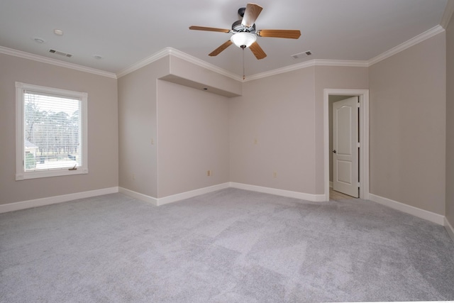 empty room with baseboards, visible vents, light colored carpet, and ornamental molding