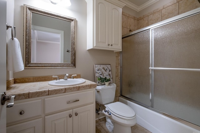 bathroom with ornamental molding, vanity, toilet, and bath / shower combo with glass door