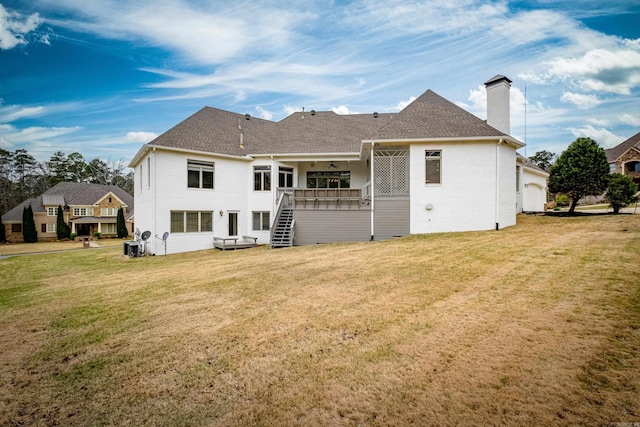 back of house with roof with shingles, a yard, a chimney, stairway, and a ceiling fan