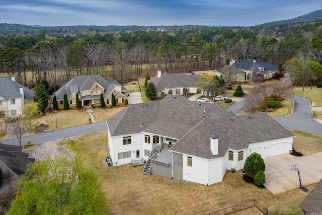 aerial view featuring a forest view and a residential view