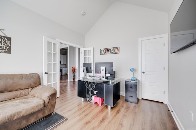 office space featuring baseboards, high vaulted ceiling, wood finished floors, and french doors