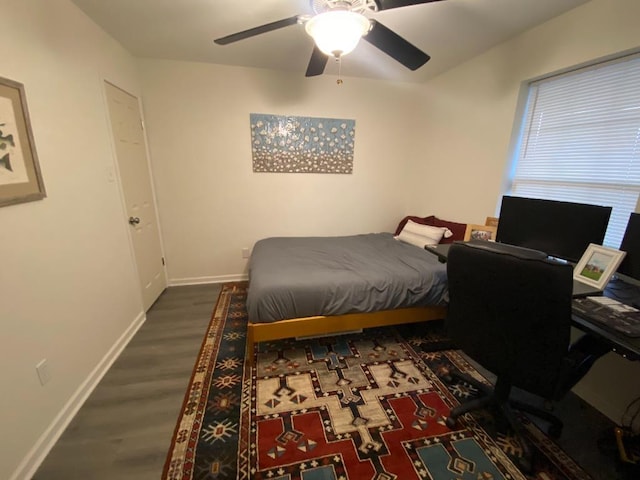 bedroom featuring a ceiling fan, baseboards, and wood finished floors