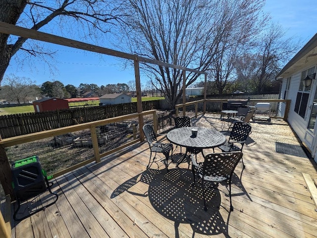 wooden deck with outdoor dining space and a fenced backyard