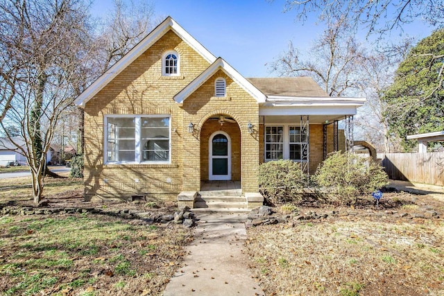 view of front of home featuring brick siding and fence