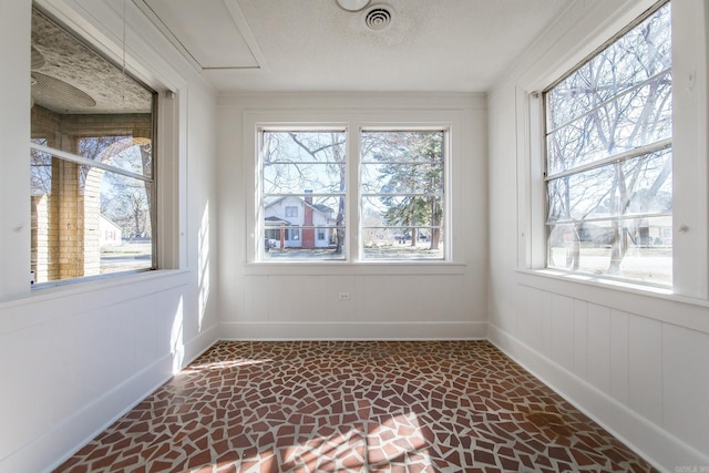unfurnished sunroom featuring plenty of natural light and visible vents