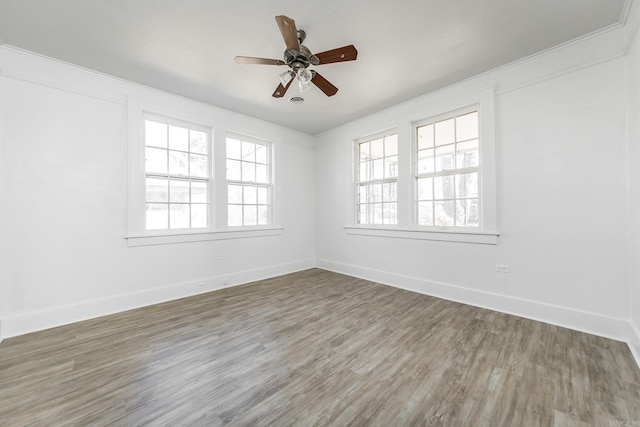unfurnished room featuring a ceiling fan, baseboards, and wood finished floors