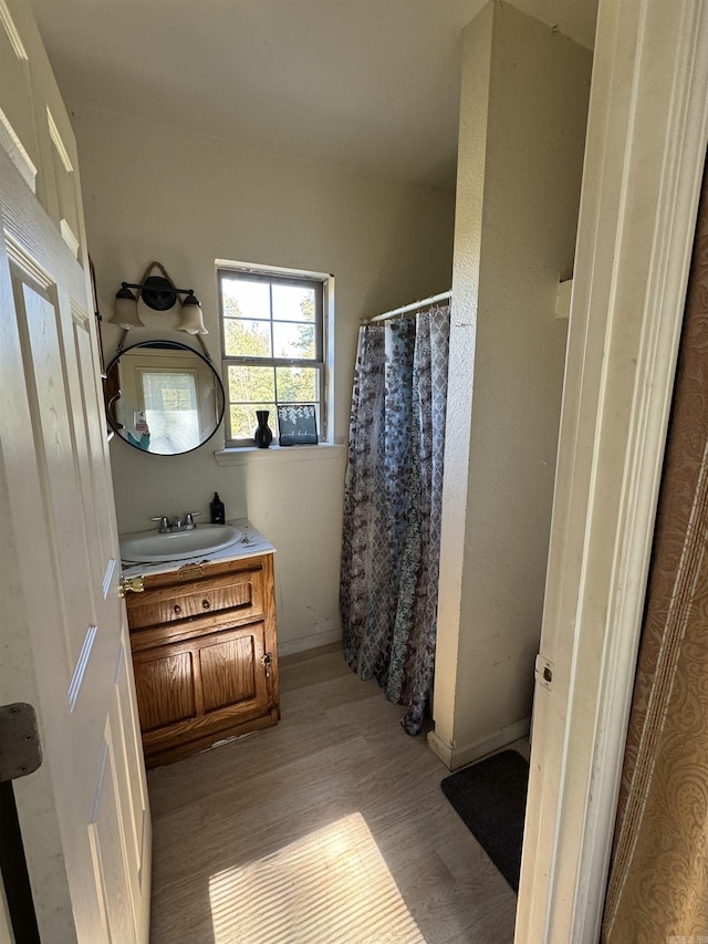 full bath featuring vanity, a shower with shower curtain, and wood finished floors