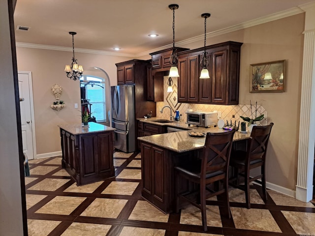 kitchen with ornamental molding, freestanding refrigerator, backsplash, and baseboards