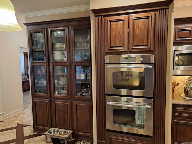 kitchen featuring appliances with stainless steel finishes, glass insert cabinets, ornamental molding, and decorative backsplash