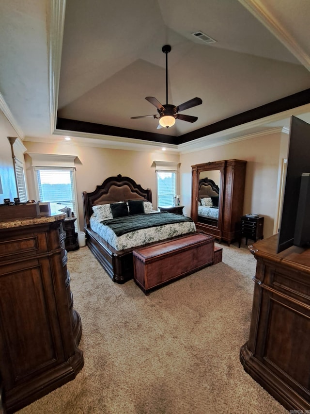 bedroom with light carpet, a tray ceiling, and crown molding