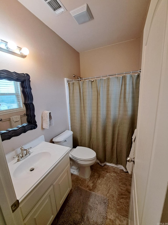 full bathroom featuring toilet, vanity, visible vents, and a shower with curtain