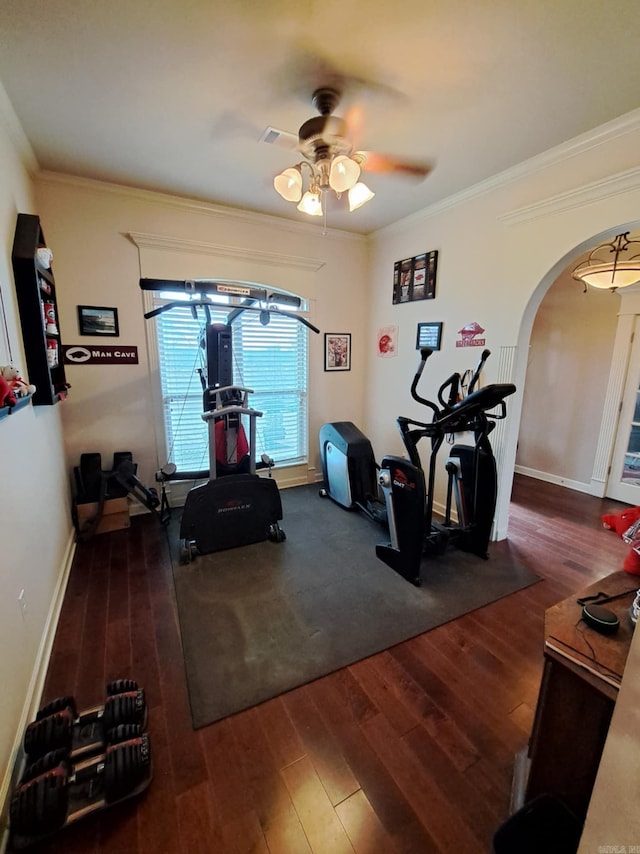 exercise room with ceiling fan, arched walkways, crown molding, and wood finished floors