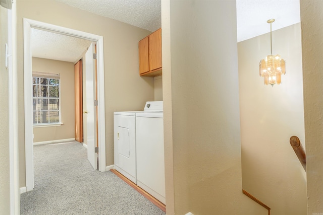 laundry room with washing machine and clothes dryer, light colored carpet, cabinet space, a textured ceiling, and baseboards