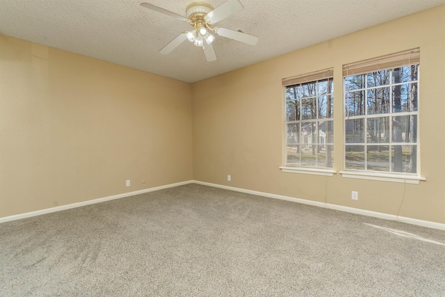 carpeted spare room with a textured ceiling, a ceiling fan, and baseboards