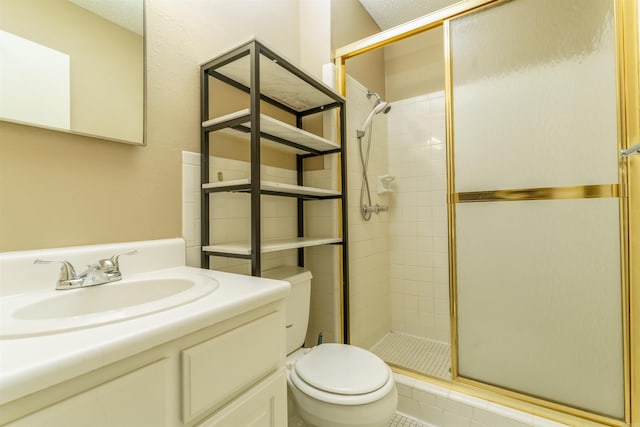 full bathroom with toilet, a stall shower, and vanity